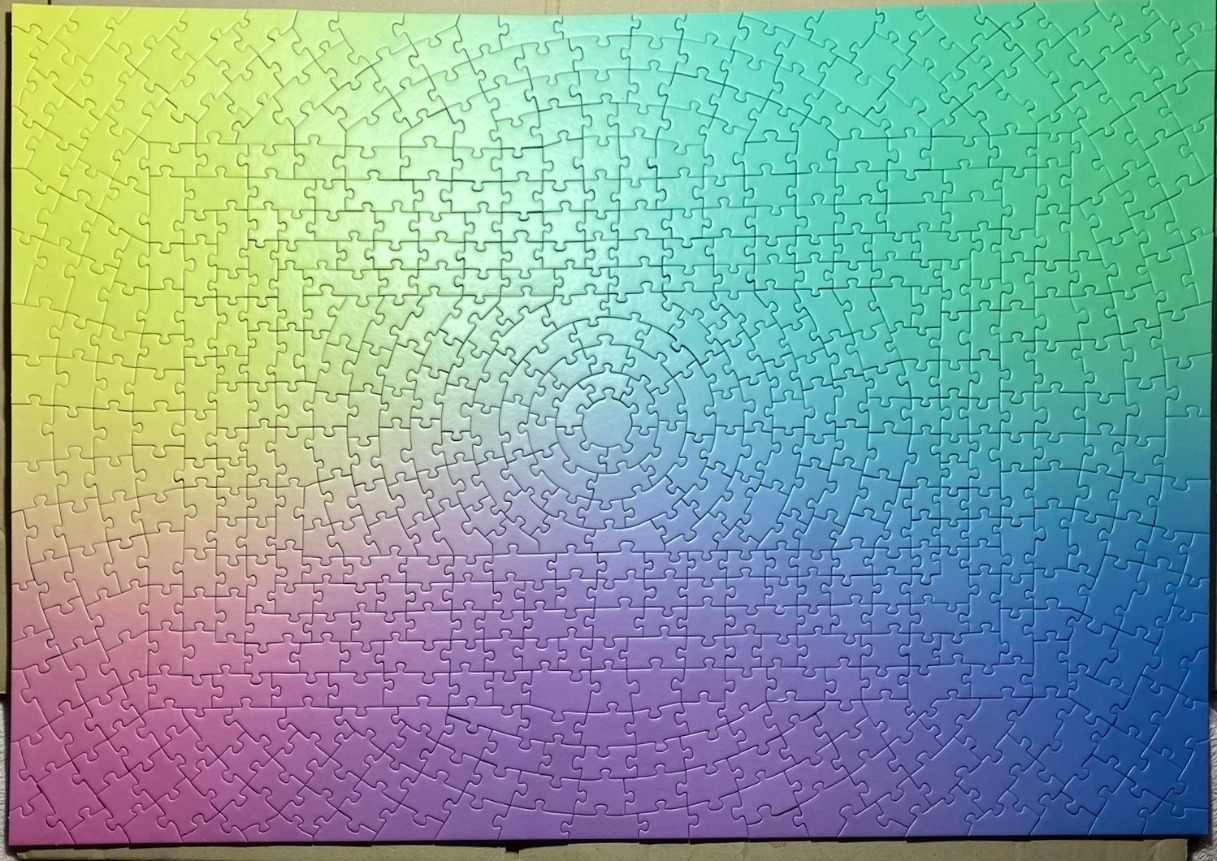 A radial spectrum gradient image transitioning from yellow to green to blue and purple in a circular pattern.