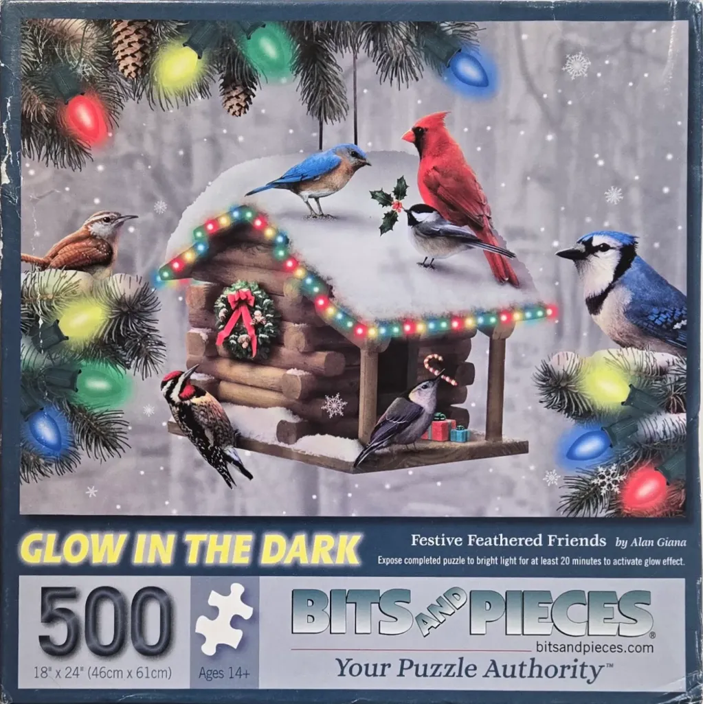 A log cabin birdhouse decorated with Christmas lights surrounded by various birds in a snowy scene.
