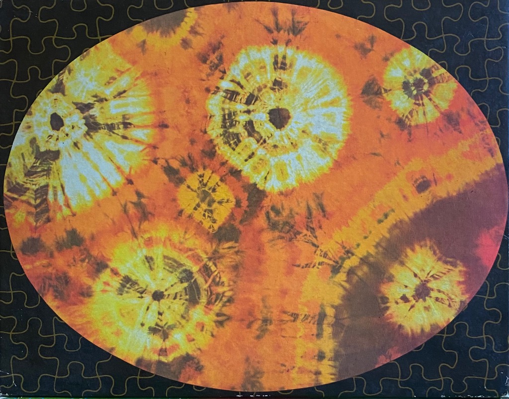 Tie-dye pattern with circular sunburst motifs in shades of bright yellow, orange, and deep red.