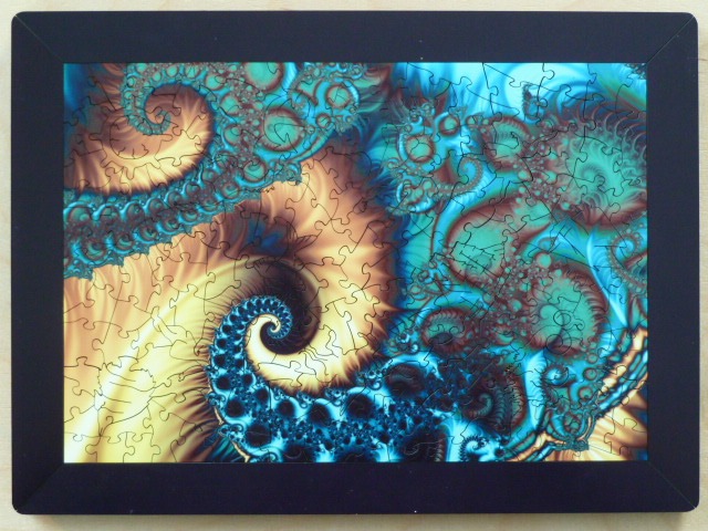 An abstract fractal image featuring swirling golden-brown and vibrant teal shapes in a repeating, complex pattern.