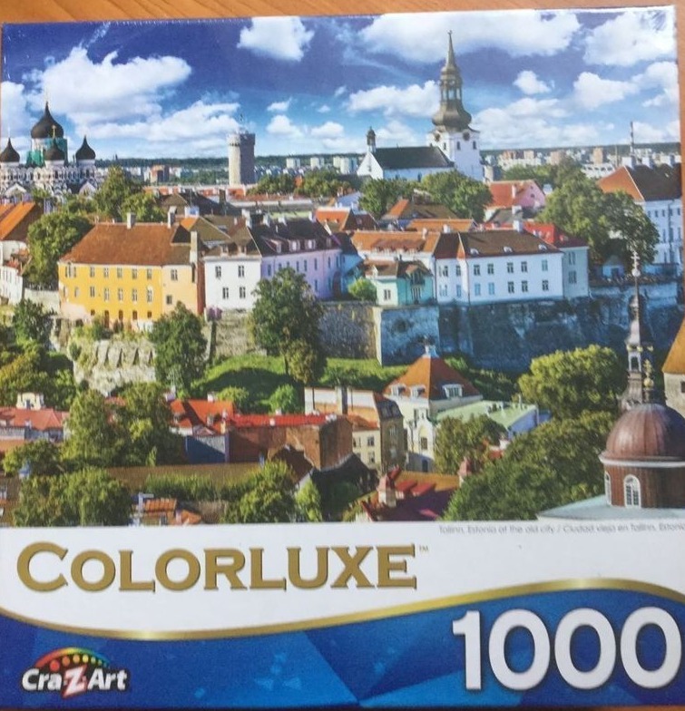 Panoramic view of the historic Tallinn skyline with colorful buildings and a bright blue sky.