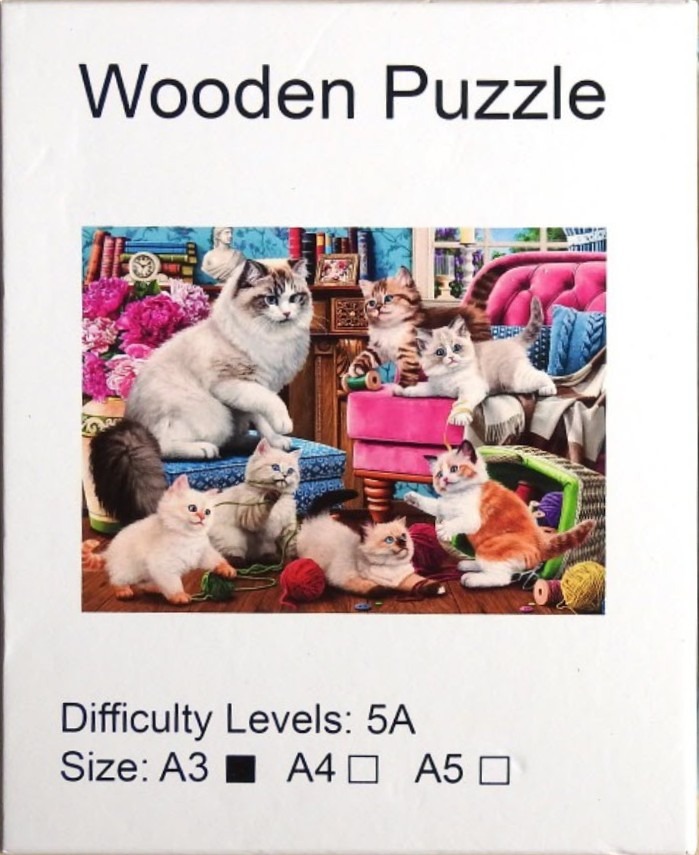 A group of six fluffy kittens playing in a cozy, book-lined room.