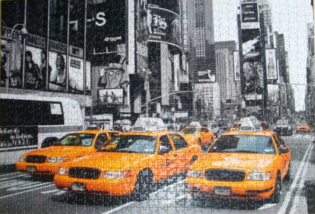 Black and white photograph of Times Square with iconic yellow taxis in the foreground.