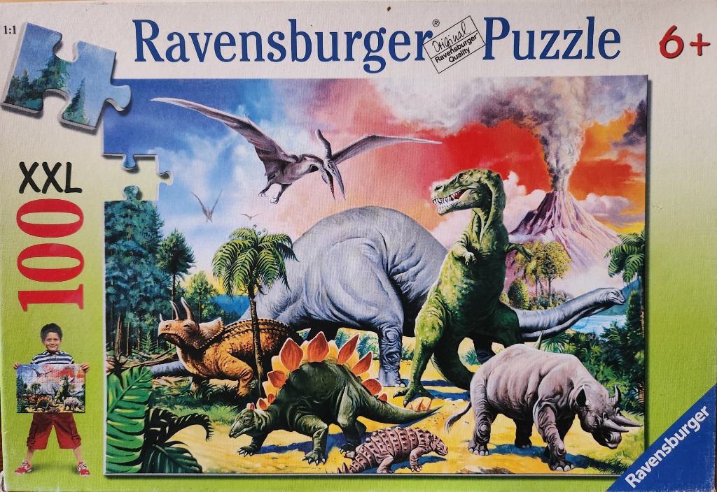 An illustration of various dinosaurs in a prehistoric landscape with a volcanic eruption in the background.
