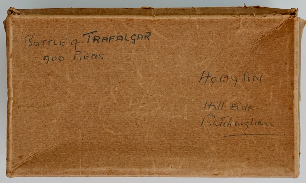 Handwritten text on a plain brown cardboard surface.