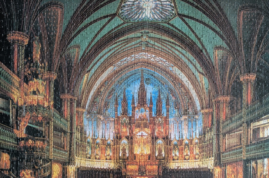 The ornate interior of Notre-Dame Basilica in Montreal with blue ceilings and gold altarpiece detailing.