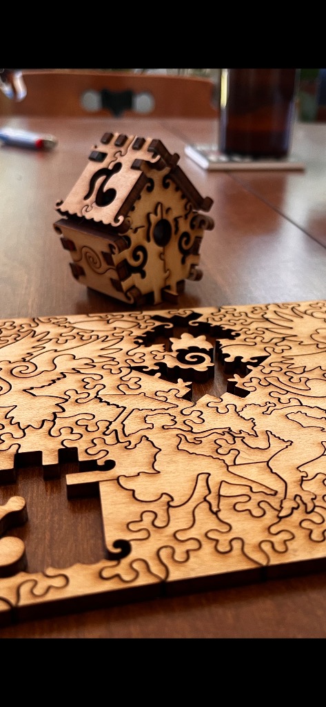 Wooden birdhouse and intricate nature-themed wooden inlay.