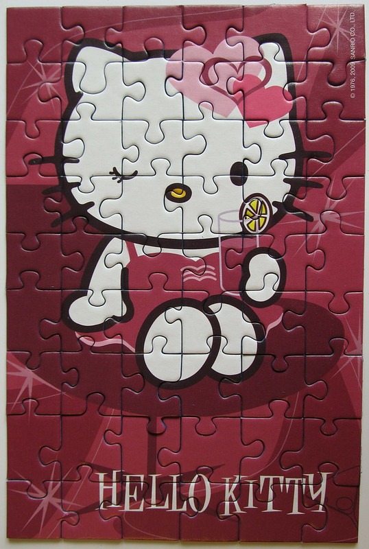 Hello Kitty drinking a glass of lemonade on a deep pink background.