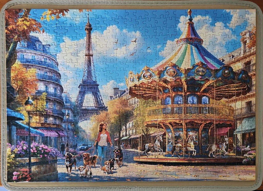 A woman walking five dogs in front of a carousel with the Eiffel Tower in the background in Paris.