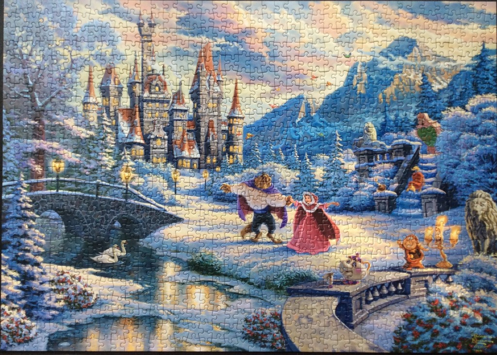 A wintery fairy tale scene featuring Belle and the Beast dancing in front of a castle.