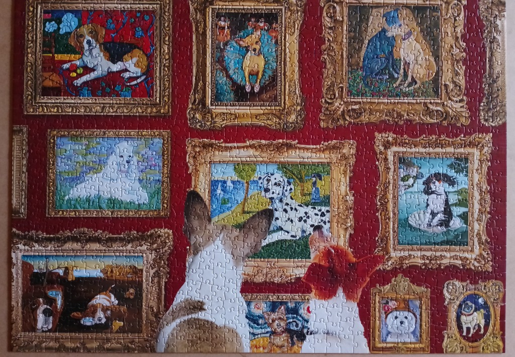A collage of various dog portraits in ornate gold frames against a deep red background.
