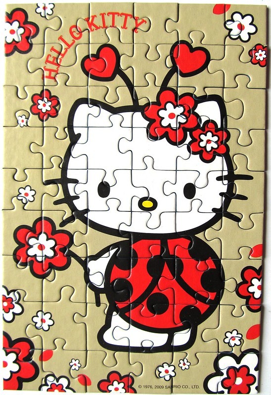 Hello Kitty dressed as a ladybug surrounded by red and white flowers on a tan background.