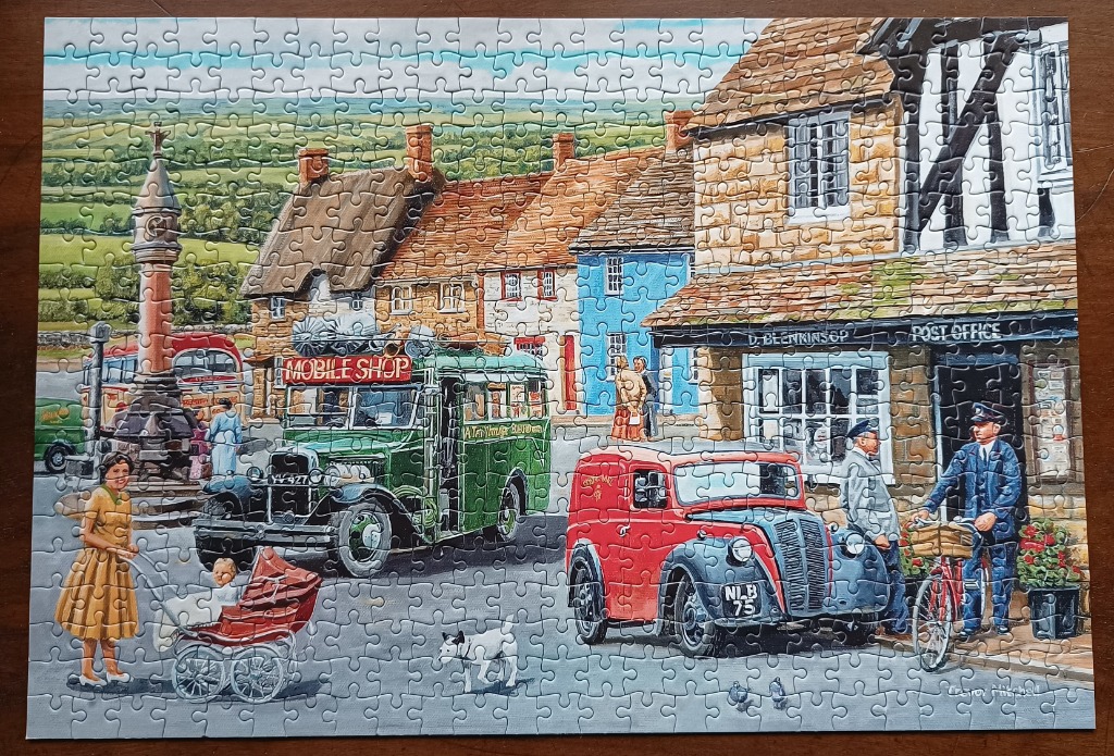 A nostalgic painting of a 1950s English village scene with vintage vehicles and stone buildings.