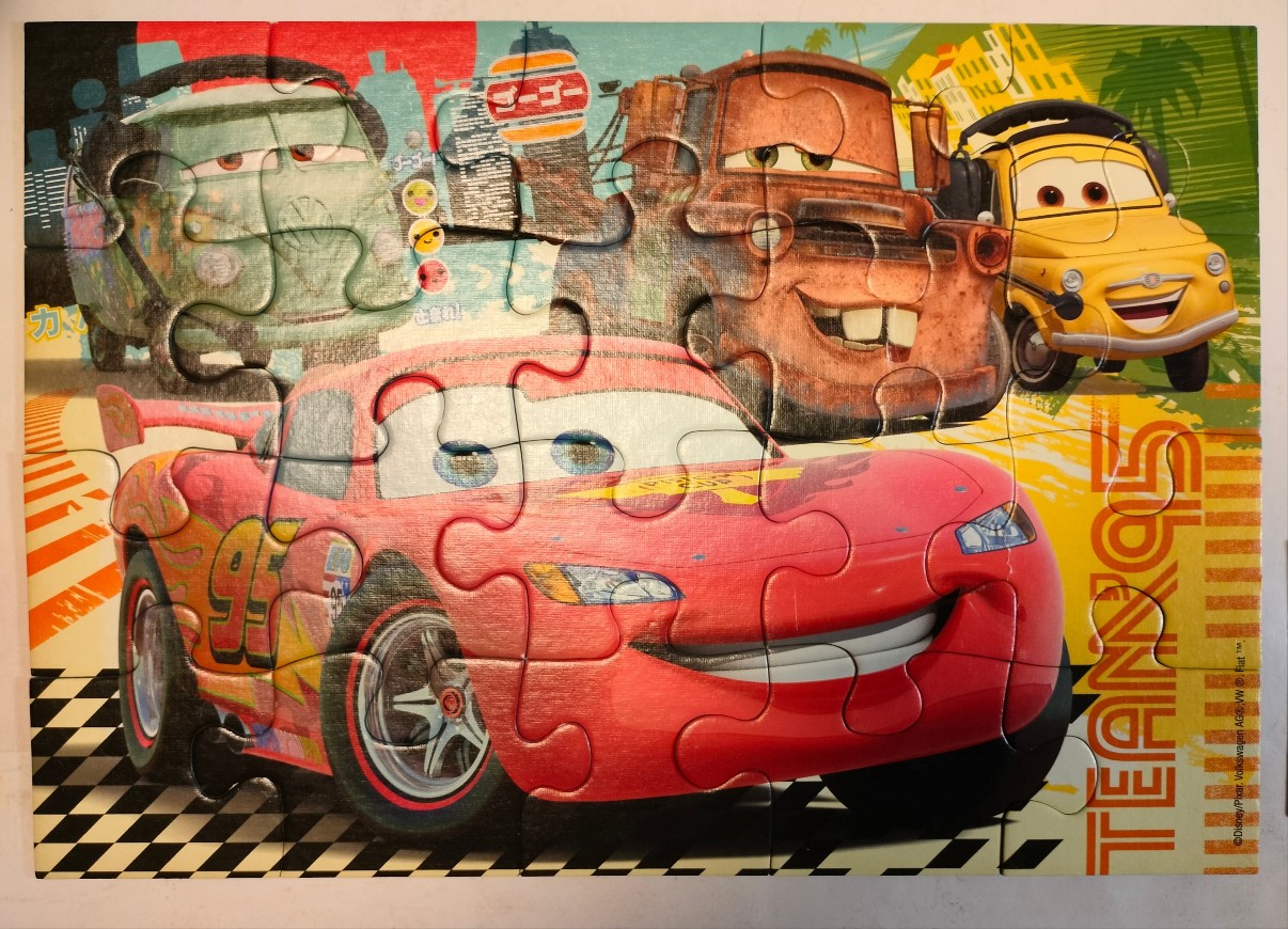 Animated racing cars including Lightning McQueen on a yellow and checkered background