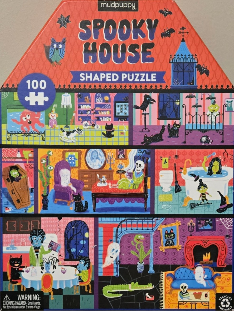 A cutaway illustration of a haunted house filled with cartoon monsters, ghosts, and spooky creatures in various rooms.