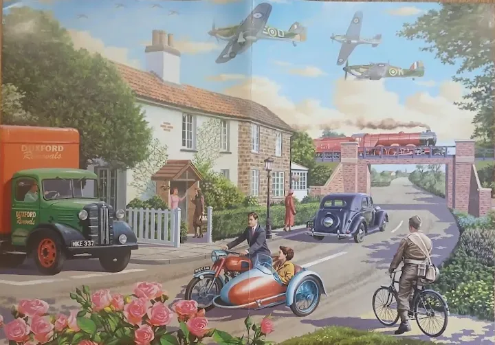 Vintage 1940s English village scene with moving vehicles and airplanes overhead.