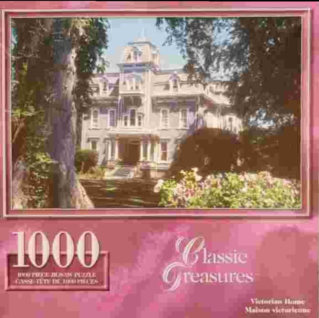 A photograph of a grand, multi-story Victorian mansion surrounded by trees and a garden.