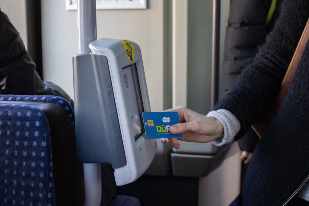 Photo d'une personne qui valide sa carte dans le bus