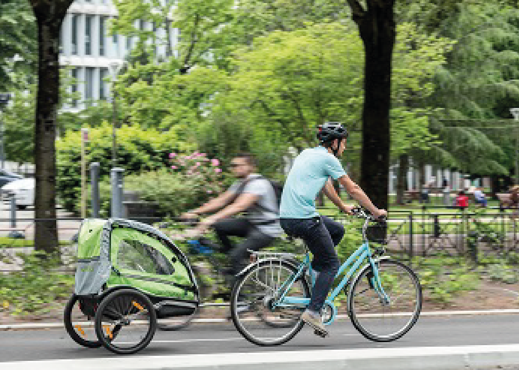 Photo d'un cycliste sur un vélo bleu à remorque