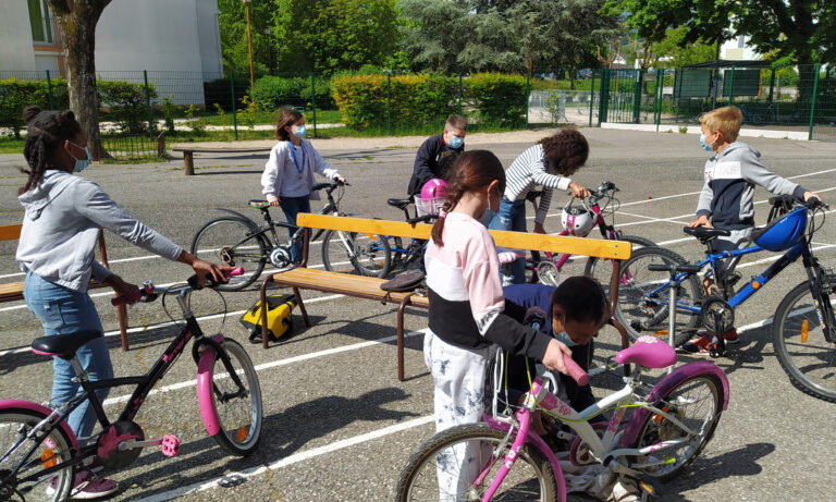 Photo d'élèves avec des vélos dans une cours de récréation