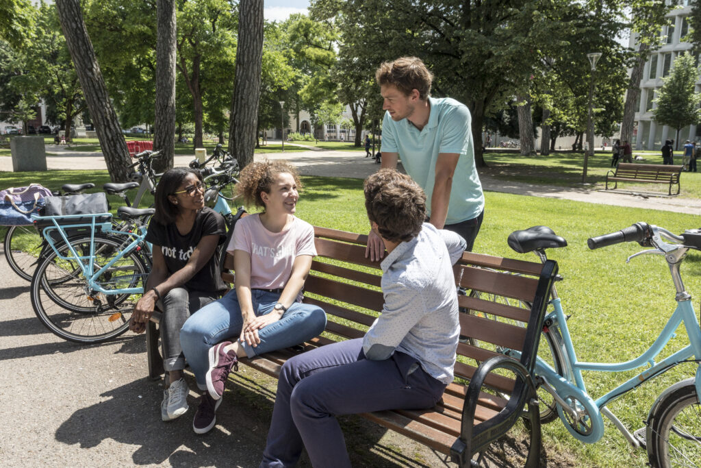 Photos de personnes assises sur un banc entourées de vélo