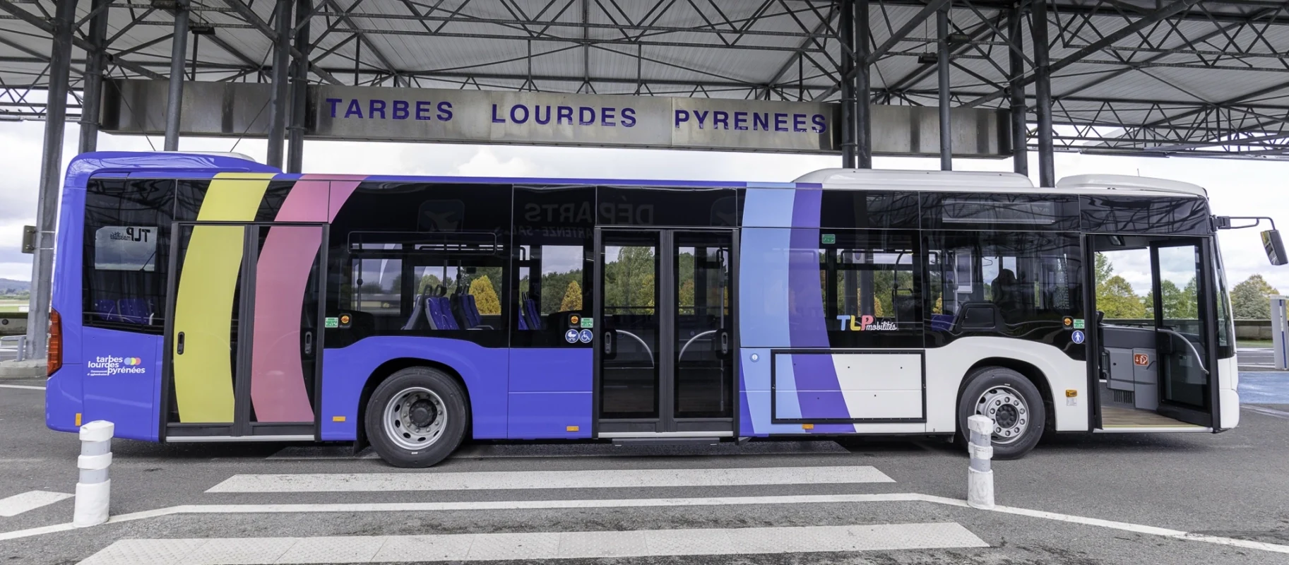 Un bus de la navette aéroport TLP Mobilités devant l'aérogare de Tarbes-Lourdes-Pyrénées.