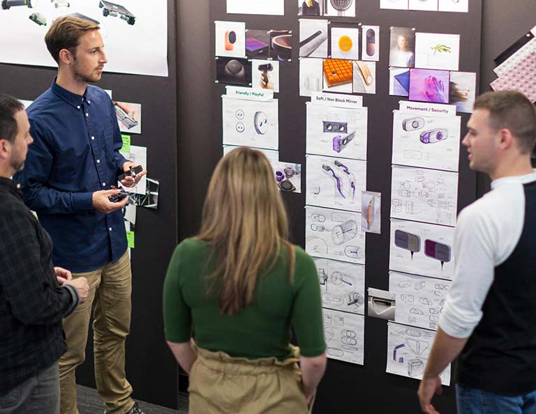 Group of people looking at blueprint designs