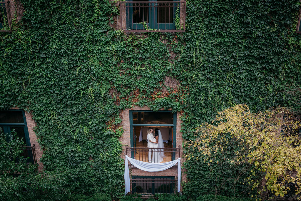 Couple in window with ivy wall