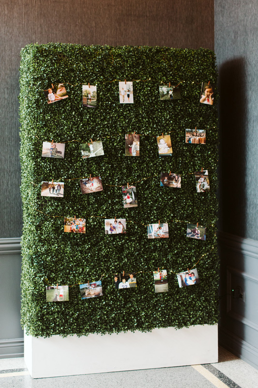 Photos on boxwood wall in foyer