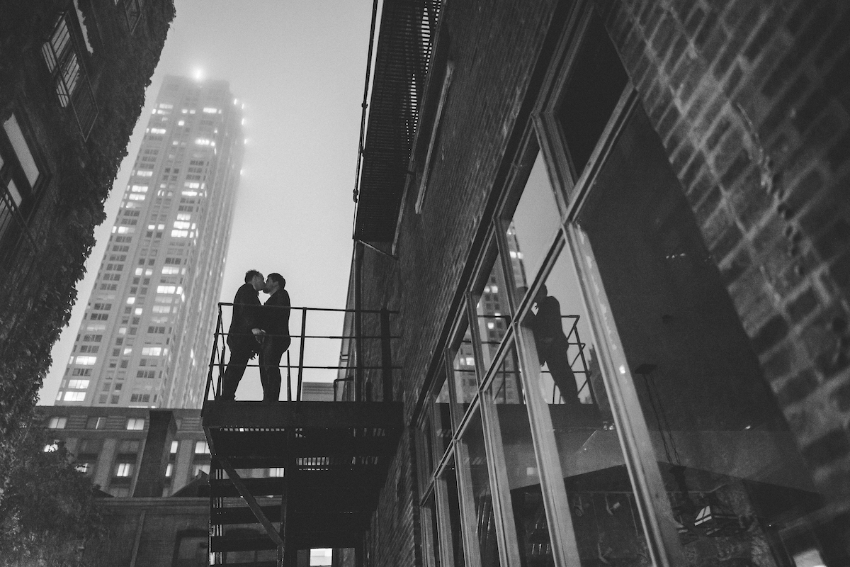 Couple at night on fire escape in courtyard