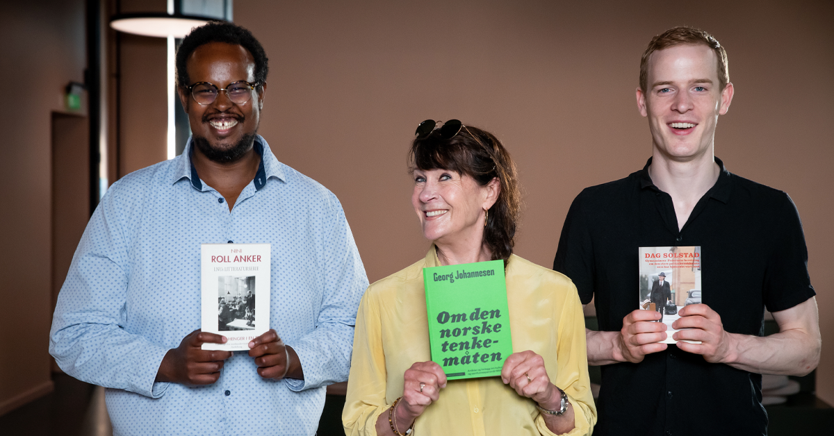 En mann, en kvinne i midten, og en mann igjen holder i hver sin bok og ler til kamera.