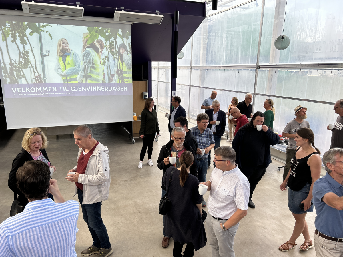 En større forsamling som snakker sammen. Foto.