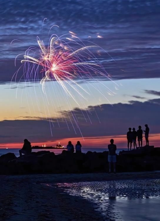 group of people watching the fireworks at 4th of july during sunset at nantucket new england