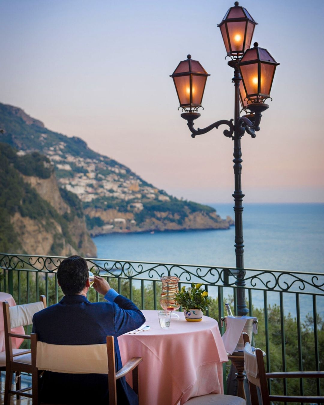 man having dinner on zass restaurant balcony in positano at sunset