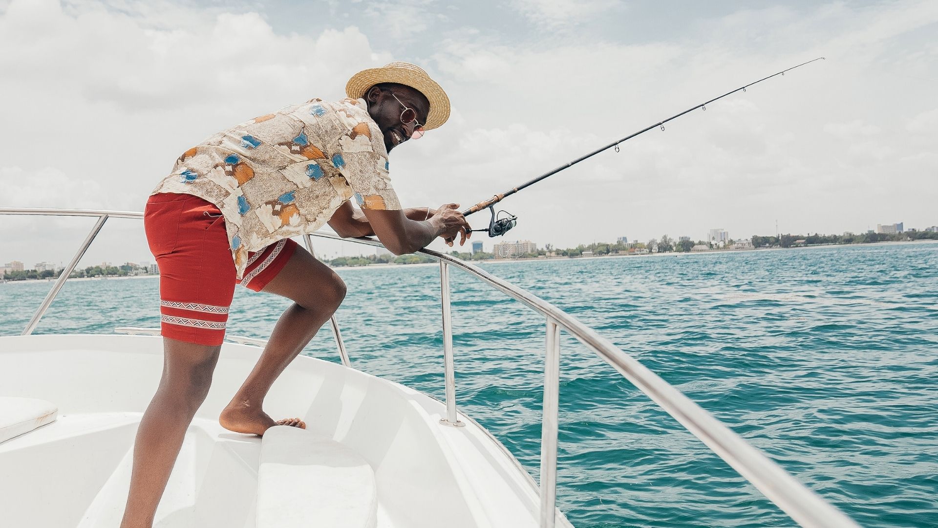 man fishing using a rod aboard a yacht in summer morning