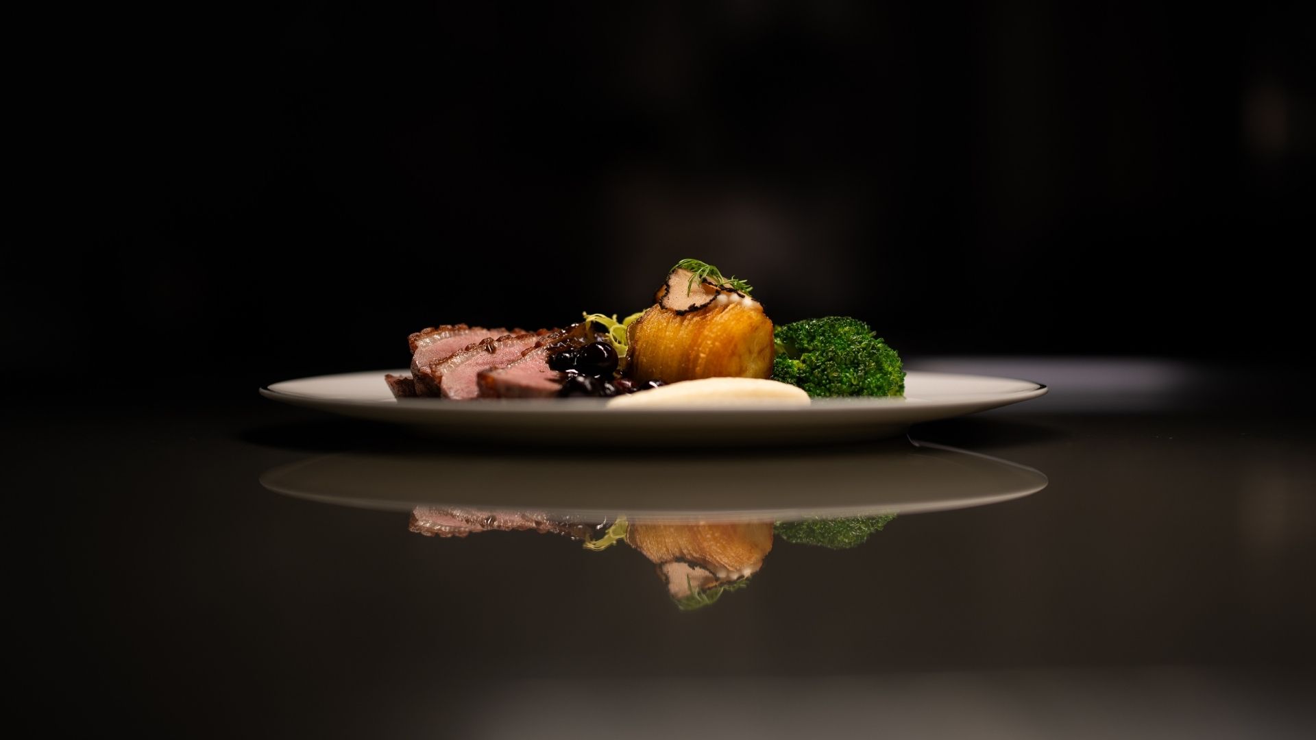 close up of fine dining plate on a black background