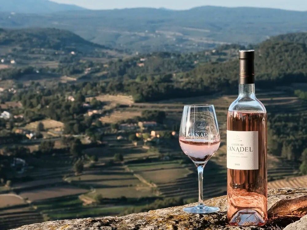 a bottle and glass of canadel wine with the Le Plan du Castellet on the background