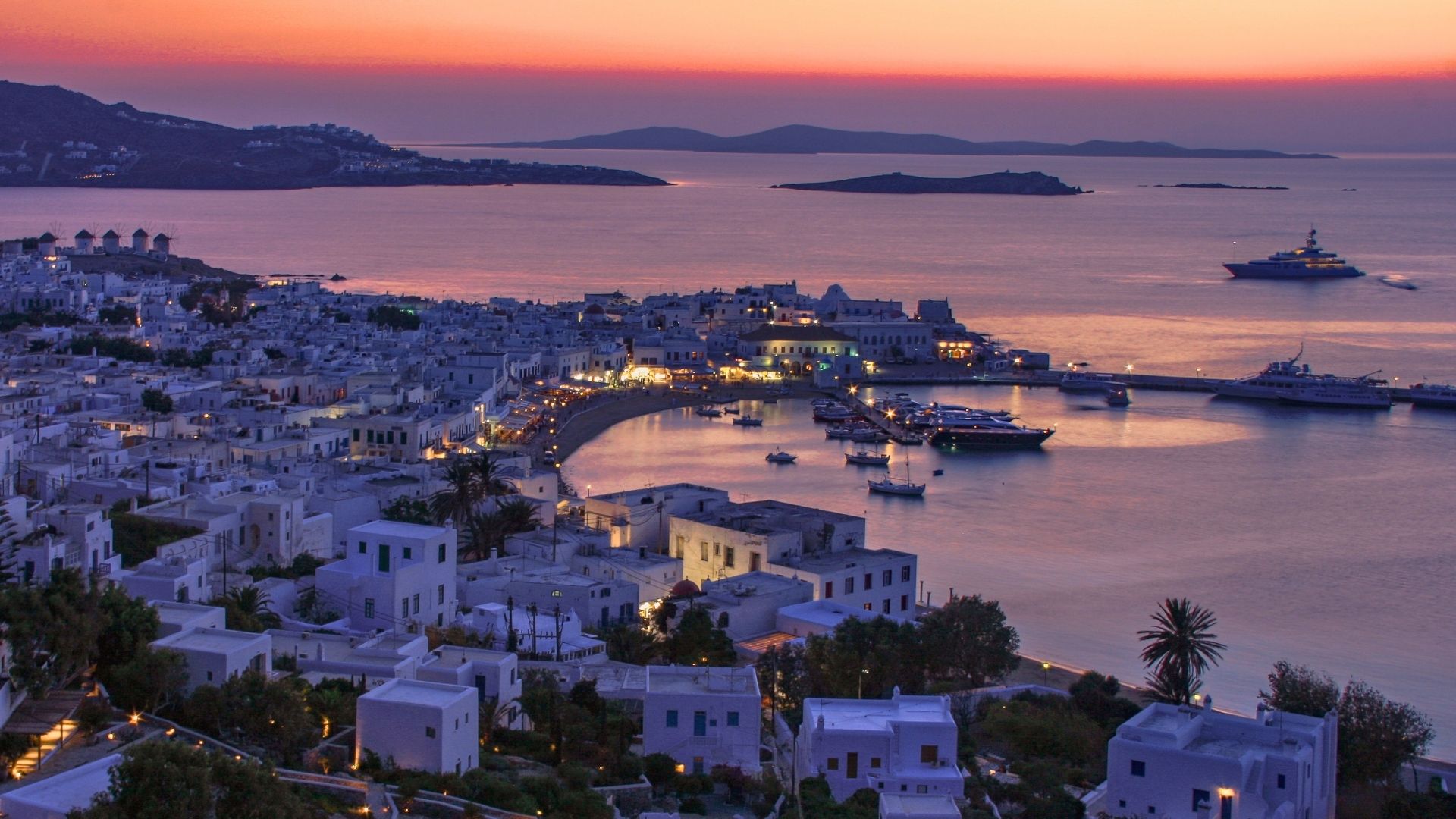 aerial view of mykonos town and port during summer sunset