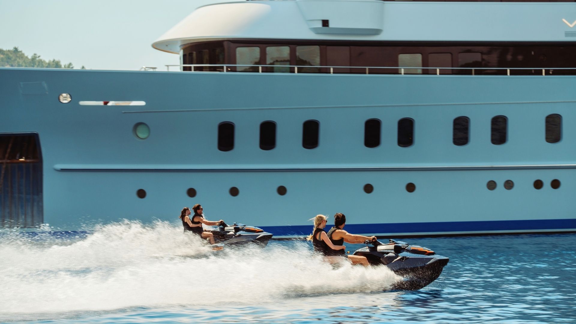 a group of fourjet skiing close to an iyc yacht