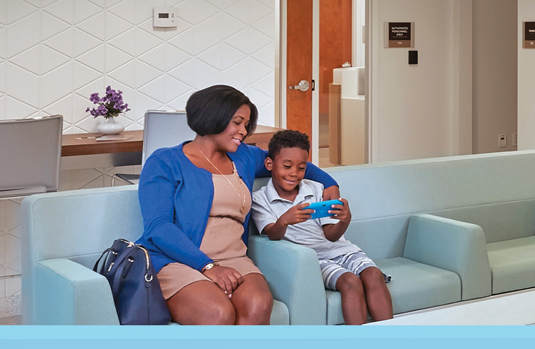 Mom and child at a local UHealth Jackson Urgent Care center, sitting in the waiting room