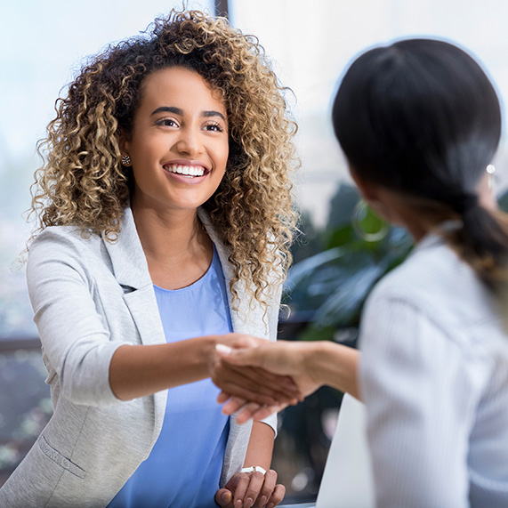 Businesswoman shakes hands with a female interviewer during a job interview.