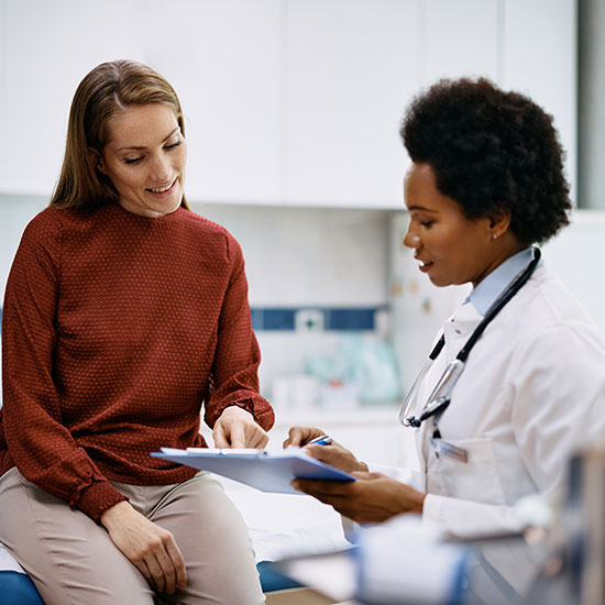 A patient and medical professional speaking, they're in a medical room