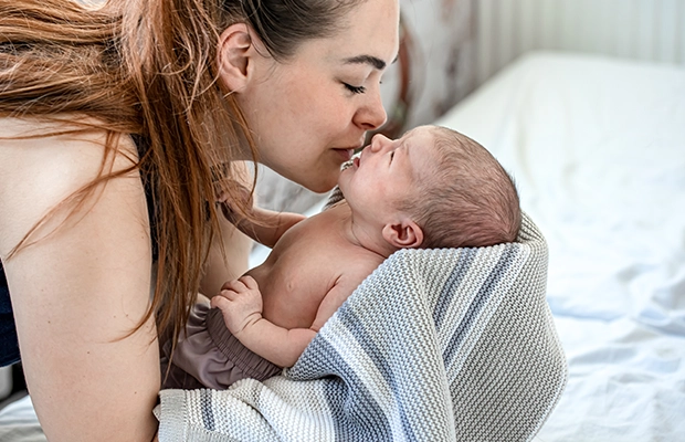 mom kissing her baby on the forehead