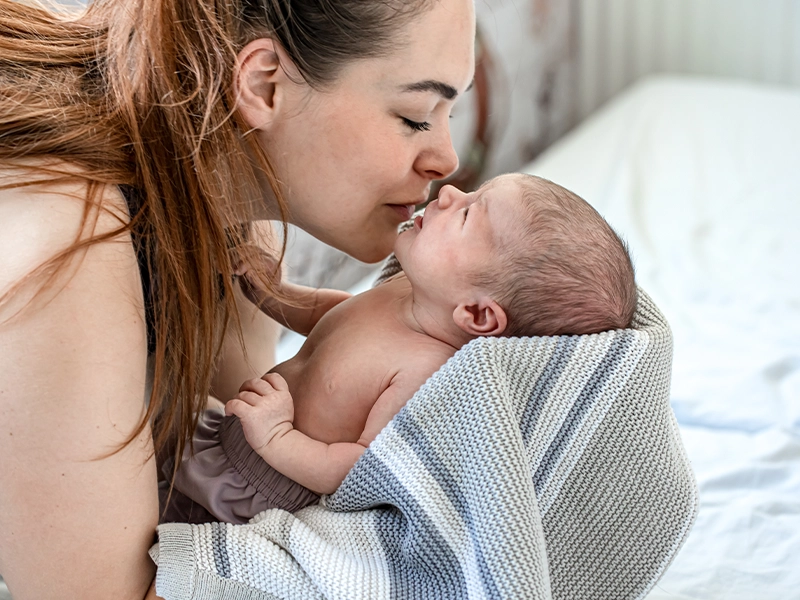 mom kissing her baby on the forehead