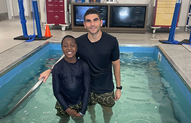 boy in the pool with his instructor