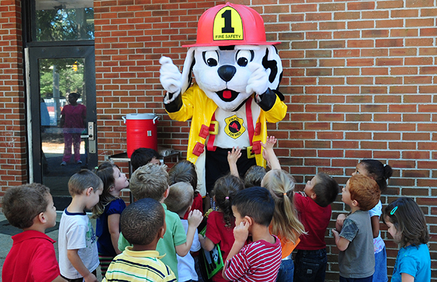 Sparky, the fire dog, interacts with children from the child development center during Fire Prevention Week at Seymour Johnson air Force Base, N.C., Oct. 8. Sparky is one of many tools the 4th Civil Engineer Squadron’s fire department uses to teach children about preventing fires. (U.S. Air Force photo/Airman 1st Class Rae Perry)