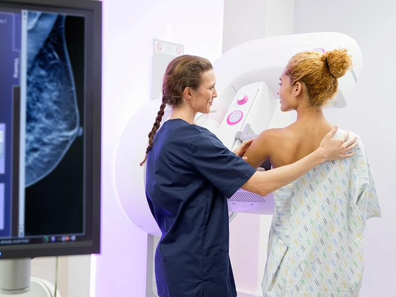 doctor performing a 3D mammogram on her patient