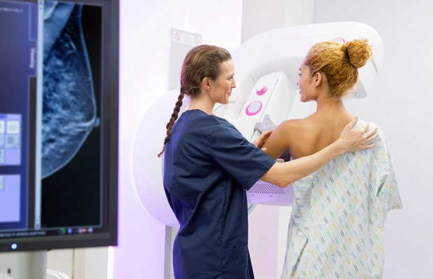 doctor performing a 3D mammogram on her patient
