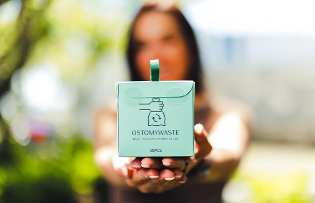 Close-up of hands showing a small green box; the background is out of focus.