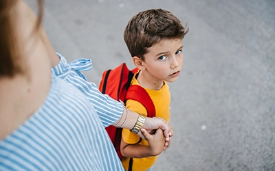 boy in yellow t-shirt holding hands with a person